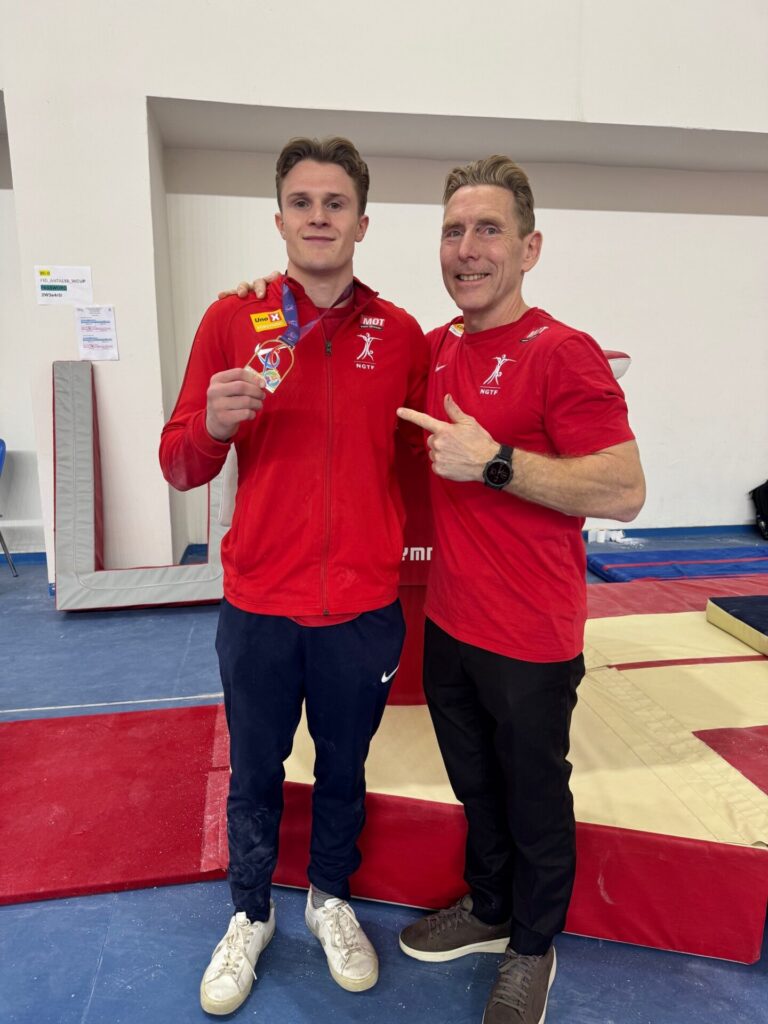 Sebastian og trener Espen Jansen viser stolt frem gull-medaljen.